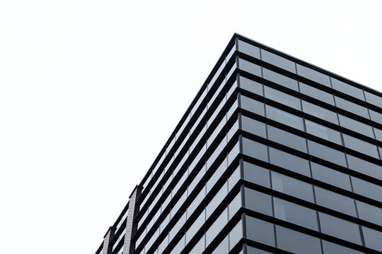 Generic corporate architecture modern building, contemporary office windows, low angle shot, simple minimal bright background, clear white sky copy space, skyscraper top, business city life concept