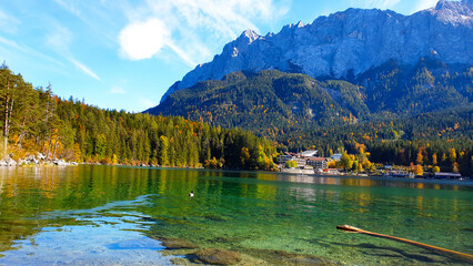 Fall in the forest. Gorgeous landscape, emerald green kristal clear lake, evergreen forest, mountain peack background, sunny day, blue sky. Hiking and relaxing in Bavarian Alps, Eibsee lake, Germany.