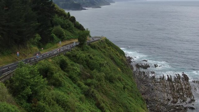 Cycling race going downhill next to the sea.