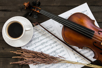music background, violin, notes, coffee cup on a wooden table