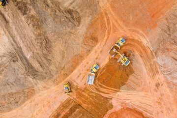 Aerial view of industrial crawler excavator in the process of work digs out the earth and pours it...