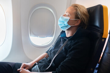 Fototapeta na wymiar A young woman wearing face mask is traveling on airplane , New normal travel after covid-19 pandemic concept.