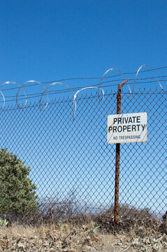 Private Property No Trespassing Warning Sign With Barbed Wire Fence