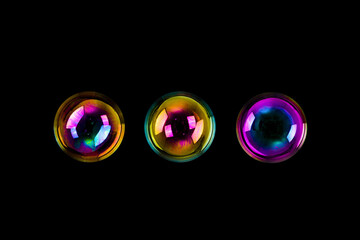 three soap bubbles isolated on black background. 