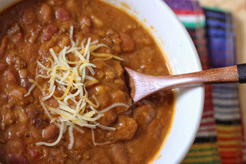 Bowl of Chili With Pinto Beans on Table With Peppers and Dry Beans in Background