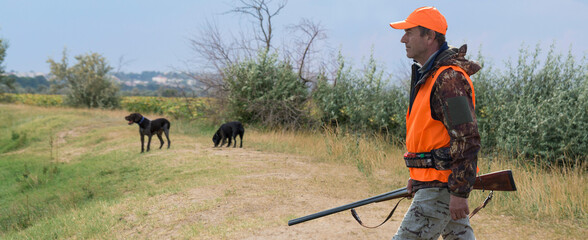 Hunter man in camouflage with a gun during the hunt in search of wild birds or game. Autumn hunting...