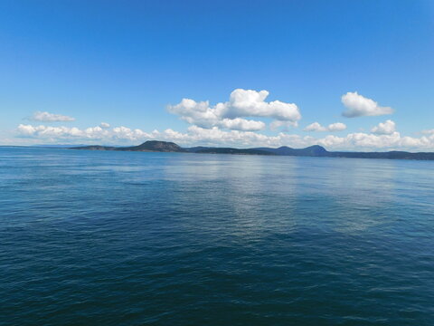 Several of the San Juan Islands amid calm seas and blue skies