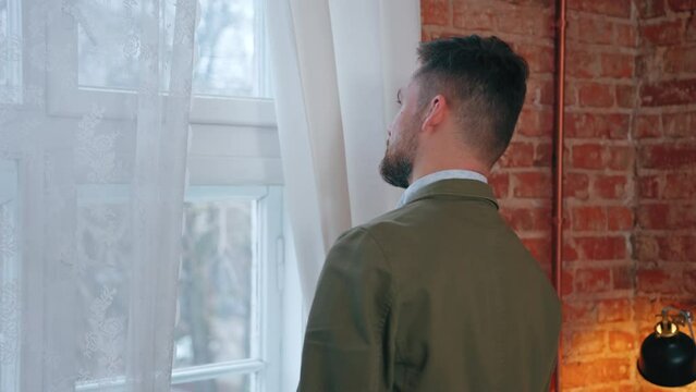 caucasian bearded brunet CEO looking out of the window middle close up shot. High quality 4k footage