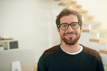 Shot of a young entrepreneur using a mobile phone in his office. Portrait of a confident young...