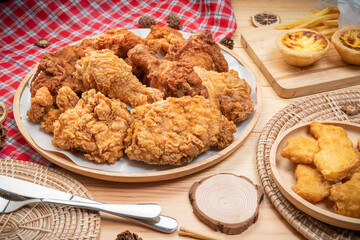 Fried chicken egg tart and french fries in wooden plate on wooden background, Deep fried Chicken and nuggets on wooden table