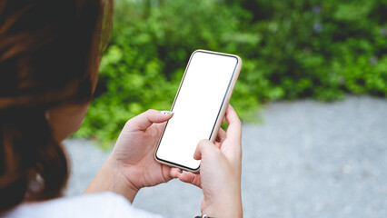 Close up women using a smartphone with empty white screen at the outdoor.