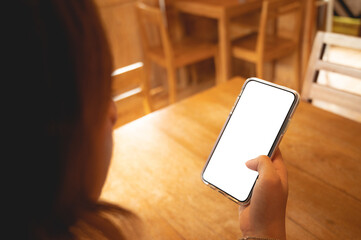 Close up women using a smartphone with an empty white screen at the wooden interior cafe.