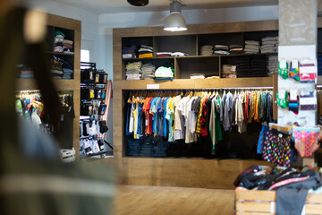 Variety of male clothes on hangers and shelves in apparel boutique