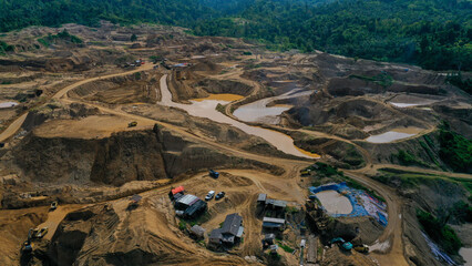 Aerial view of Work of trucks and the excavator in an open pit on gold mining. Central Sulawesi,...
