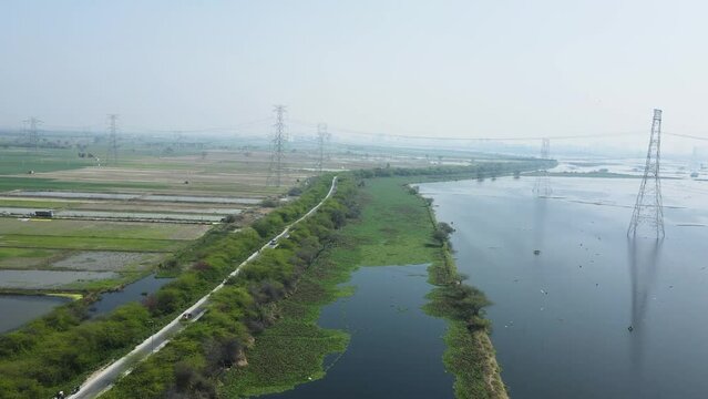 Aerial panning drone shot of agricultural lands covered in water due to floods in India.