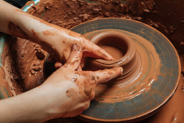 Potter at work on circle wheel in workshop