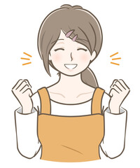 ガッツポーズをして喜ぶエプロン姿の若い女性