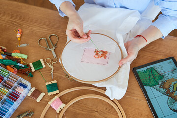 Top view female hands holding embroidery hoop, needlework concept, hobby