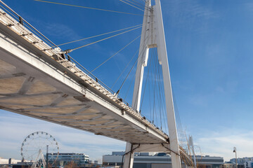 Obraz premium Modern pedestrian bridge against the blue sky. Bottom view