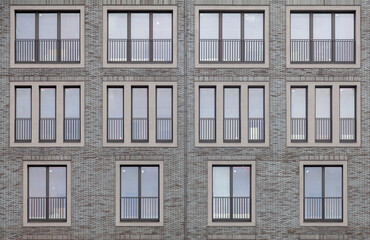 Background image - brick wall of a building with windows of different sizes