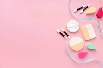 Obraz na płótnie Canvas Makeup flat lay. Various foundation sponges and eyeshadow applicators on pink background, space for text