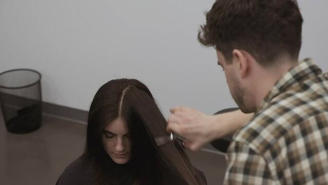 Stylist texturizes client's thick long hair with angled shears cuts