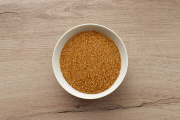 Sugar cane in a bowl on wooden background. Top view.