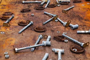 Studs, bushings, nuts, washers lie on the deck after cargo unfastening. D-rings are welded onto the deck.