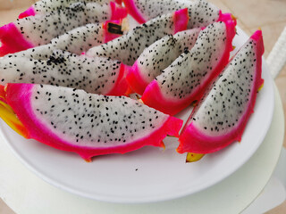 Pink outside and white inside with black seeds pitahaya (pitahaya or dragon's eye) - the fruit of Hylocereus cacti, cut into slices