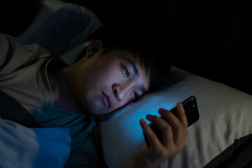 Young Asian man using smartphone at night