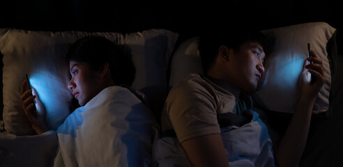 Young Asian couple using smartphone at midnight