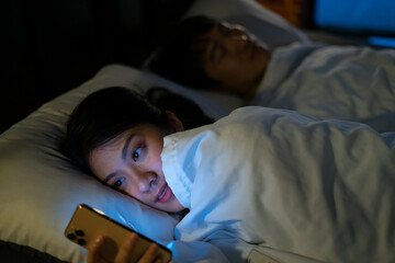 Young Asian woman using smartphone at midnight - obrazy, fototapety, plakaty