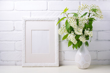 White frame mockup with blooming bird cherry in the decorated vase