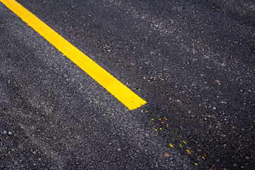 Asphalt road surface with yellow line 