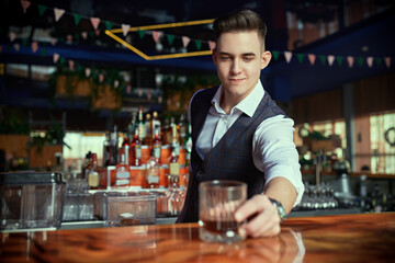 handsome waiter serves drink