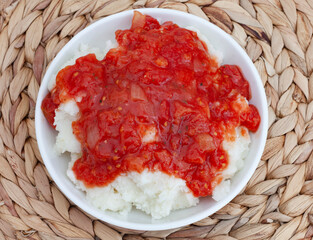 Traditional South African Pap and sous, maize meal covered in tomato and onion relish

