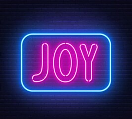 Neon sign Joy on brick wall background.