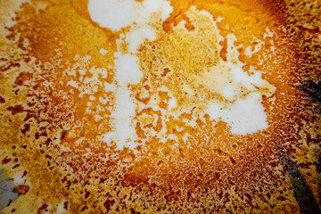 Abstract yellow-orange burning cream texture in white background. Milk burning pots orange-yellow...