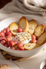 Baked brie cheese with bread and grapes