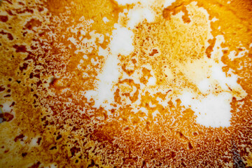 Abstract yellow-orange burning cream texture in white background. Milk burning pots orange-yellow...