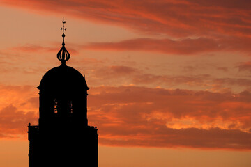 The tower of the Great Church in Deventer, the Netherlands, against a dramatic sky at sunset
