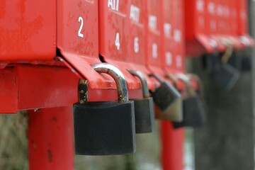 Traditional red mailbox locked with metal padlocks