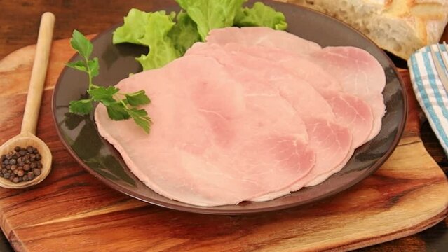 slice of white ham in a plate on a wooden board