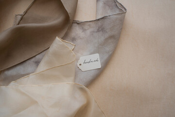 close up of hand dyed clothes in warm natural tones  - studio shot -
slow fashion concept  - 490478363