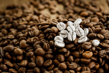 Silver coffee beans on a pile of coffee beans. The concept of luxury is extraordinary