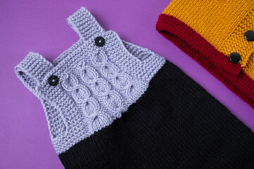 Knitted clothes color background. Handmade children's clothing. Knitted suit top view flat composition. The concept of hobby, individual marketing, entrepreneurship. Autumn time is cozy and warm.