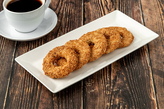 Turkish name Kandil simidi with tea beside it on wooden table. Turkish Bagel with sesame seeds or salty ring cookies.
