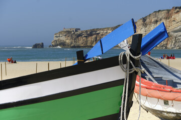 Fototapeta na wymiar old colorful traditional fishing boats on Nazare Beach, Portugal