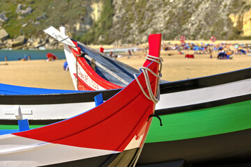Fototapeta na wymiar old colorful traditional fishing boats on Nazare Beach, Portugal