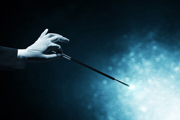 Magician hand holding magic wand - obrazy, fototapety, plakaty